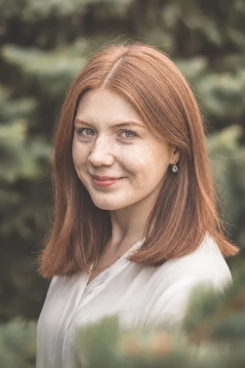 The same woman with a shoulder-length auburn cut, blunt through the ends.